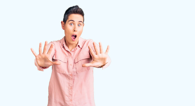 Young woman with short hair wearing casual clothes doing stop gesture with hands palms, angry and frustration expression