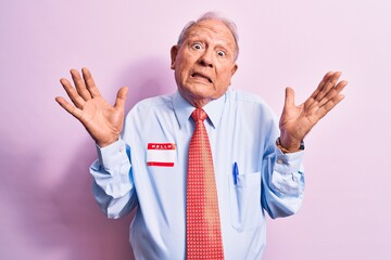 Senior handsome grey-haired businessman wearing tie and shirt with name presentation sticker...