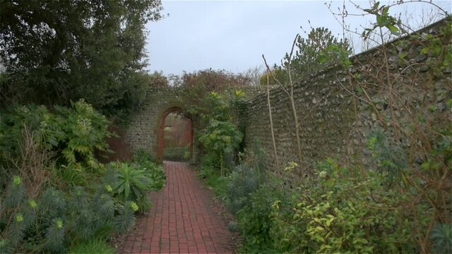 Left-tracking shot of a pathway through a walled Secret Garden in the South of England