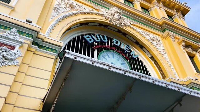 Clock Displayed Above The Entrance At The Exterior Of Saigon Central Post Office In Ho Chi Minh City, Vietnam - dolly tilt-up shot