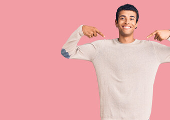 Young african amercian man wearing casual clothes looking confident with smile on face, pointing oneself with fingers proud and happy.