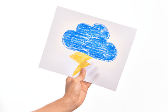 Holding paper sheet with a drawing of a blue cloud with a lightning, thunderstorm forecast weather