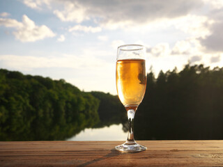 Close-up on a glass of wine on a table with a lake in background