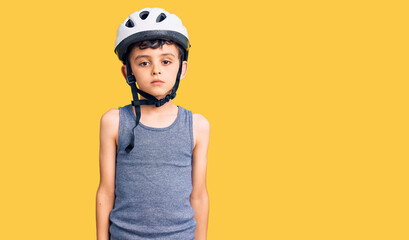 Little cute boy kid wearing bike helmet with serious expression on face. simple and natural looking at the camera.