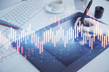 Double exposure of financial graph sketch hologram and woman holding and using a mobile device. Stock exchange concept.