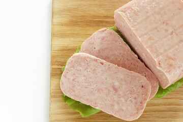 luncheon meat sliced prepared ingredient on wooden board