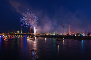 Outdoor night scenery of firework over Rhein River in Düsseldorf during Rheinkirmes Festival in Summer season.