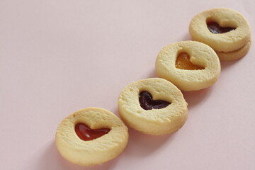 Heart shaped Jam cookie on pink background with copy space