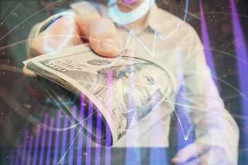 Multi exposure of financial graph drawing hologram and USA dollars bills and man hands. Analysis concept.