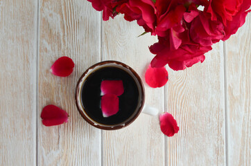 Fresh morning coffee and a pleasant home atmosphere. A cup of coffee with rose petals