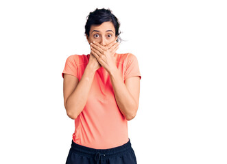 Young beautiful hispanic woman wearing sportswear shocked covering mouth with hands for mistake....