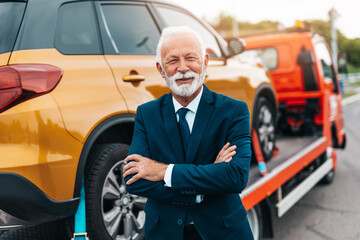 Elegant senior businesman is happy and satisfied with fast and reliable towing service for help on...