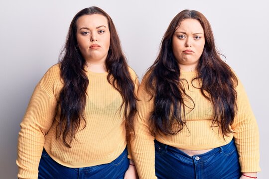 Young plus size twins wearing casual clothes depressed and worry for distress, crying angry and afraid. sad expression.