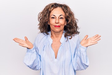 Middle age beautiful brunette woman wearing striped shirt standing over white background clueless...