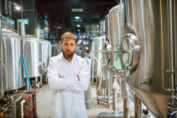  Portrait of professional caucasian handsome technologist expert in white uniform standing in pharmaceutical or food factory  - production plant