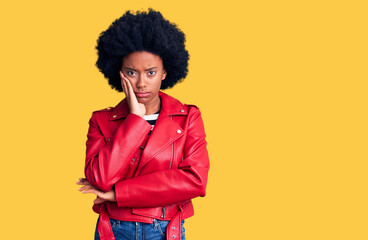 Young african american woman wearing red leather jacket thinking looking tired and bored with depression problems with crossed arms.