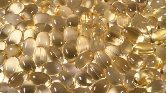 Organic supplements vitamins yellow capsules Omega 3 or D-3 pills, macro shot. Dietary supplement, close up
