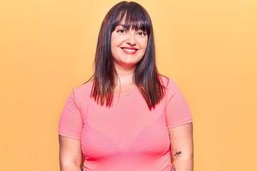 Young plus size woman wearing casual clothes looking positive and happy standing and smiling with a confident smile showing teeth