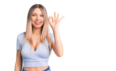 Young beautiful blonde woman wearing casual clothes smiling positive doing ok sign with hand and fingers. successful expression.