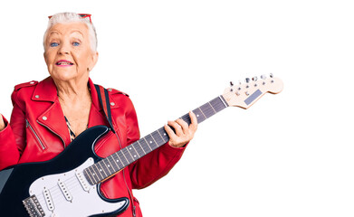 Fototapeta premium Senior beautiful woman with blue eyes and grey hair wearing a modern look playing electric guitar smiling cheerful presenting and pointing with palm of hand looking at the camera.