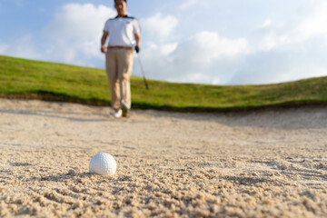 Golfers get ready to exploding sand in the bunker. Outdoor sports and recreation Concept.