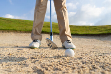 Golfers get ready to exploding sand in the bunker. Outdoor sports and recreation Concept.