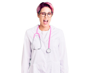 Young beautiful woman with pink hair wearing doctor uniform winking looking at the camera with sexy...