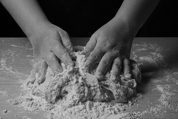 kneading homemade bread with flour on wooden table, selective focus.