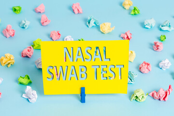 Text sign showing Nasal Swab Test. Business photo text diagnosing an upper respiratory tract infection through nasal secretion Colored crumpled papers empty reminder blue floor background clothespin