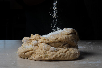 homemade dough with flour on wooden table, selective focus.