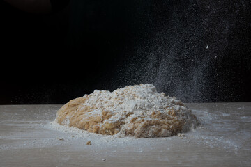 homemade dough with flour on wooden table, selective focus.