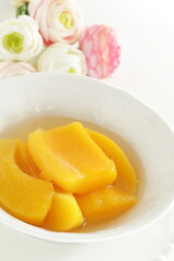Canned food, mango and syrup in white bowl