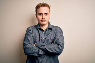 Fototapeta premium Young handsome redhead man wearing casual shirt standing over isolated white background skeptic and nervous, disapproving expression on face with crossed arms. Negative person.