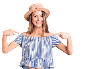 Obraz na płótnie Canvas Young beautiful girl wearing hat and t shirt looking confident with smile on face, pointing oneself with fingers proud and happy.