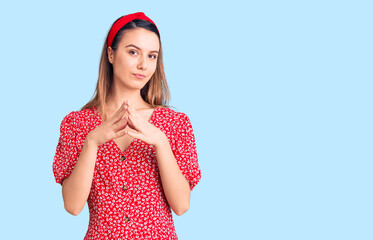 Young beautiful girl wearing dress and diadem hands together and fingers crossed smiling relaxed and cheerful. success and optimistic