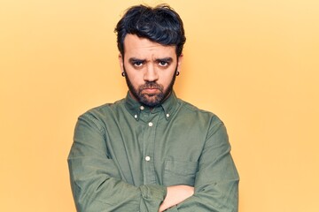 Young hispanic man wearing casual clothes skeptic and nervous, disapproving expression on face with crossed arms. negative person.