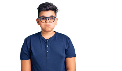 Little boy kid wearing casual clothes and glasses puffing cheeks with funny face. mouth inflated with air, crazy expression.