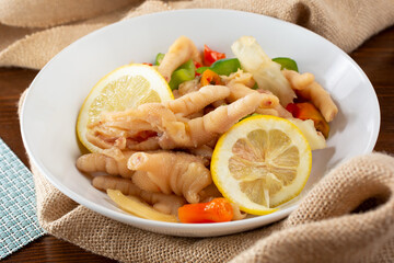 A view of a plate of chicken feet stir fry, in a restaurant or kitchen setting.