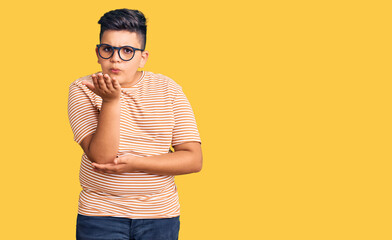 Fototapeta premium Little boy kid wearing casual clothes and glasses looking at the camera blowing a kiss with hand on air being lovely and sexy. love expression.