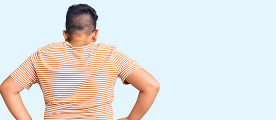 Little boy kid wearing casual clothes and glasses standing backwards looking away with arms on body
