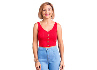 Obraz premium Young blonde woman wearing casual clothes looking positive and happy standing and smiling with a confident smile showing teeth