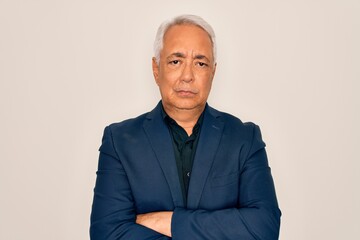 Middle age senior grey-haired handsome man wearing elegant business jacket skeptic and nervous, disapproving expression on face with crossed arms. Negative person.