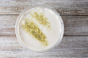 A top down view of a foamy Taiwanese boba tea drink featuring a dash of matcha powder.