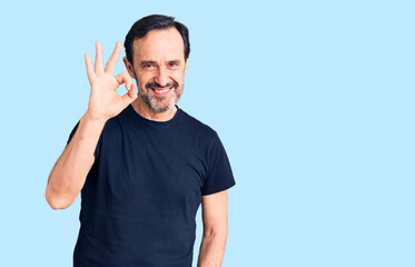 Fototapeta premium Middle age handsome man wearing casual t-shirt smiling positive doing ok sign with hand and fingers. successful expression.