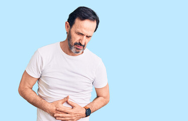 Middle age handsome man wearing casual t-shirt with hand on stomach because indigestion, painful illness feeling unwell. ache concept.