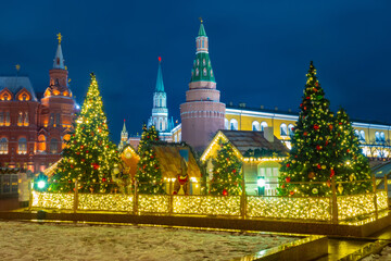 Fototapeta premium Moskwa. Rosja. Noworoczne dekoracje rosyjskiej stolicy. Świąteczne dekoracje na tle Kremla. Poczucie świętowania. Choinki i girlandy na placu czerwonym.