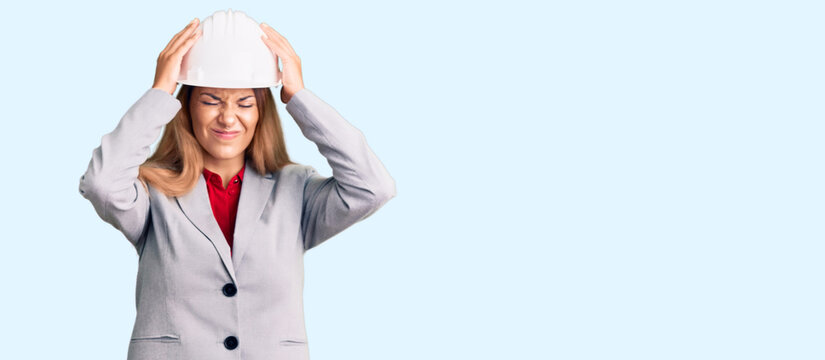 Beautiful young woman wearing architect hardhat suffering from headache desperate and stressed because pain and migraine. hands on head.