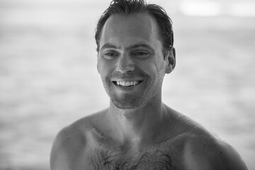 Portrait of handsome happy, sexy man with body, surfer  and blue ocean