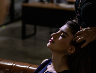 Young attractive female worker feels relax and paint relieved while her colleague gives her head...