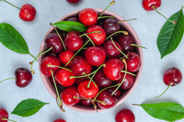 Cherry with leaf on plate and water dropsand on grey stone table